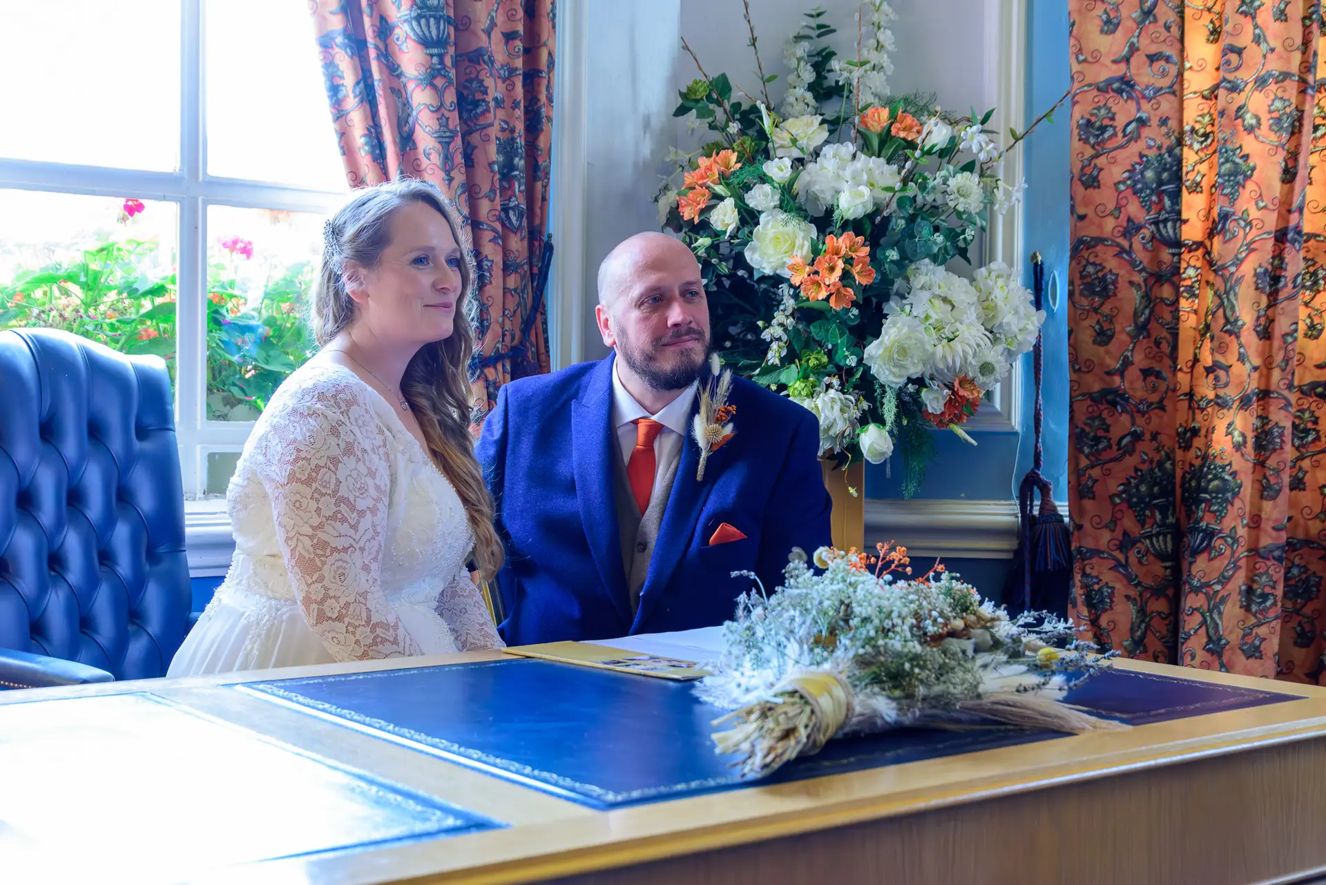Bride and groom sitting at the signing table during their wedding ceremony at City Hall Cardiff