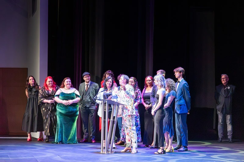 The cast and crew of New Beginnings stand on stage as an acceptance speech is delivered at the It's My Shout Awards at ICC Newport. Event photography by Hannah Clegg Photography