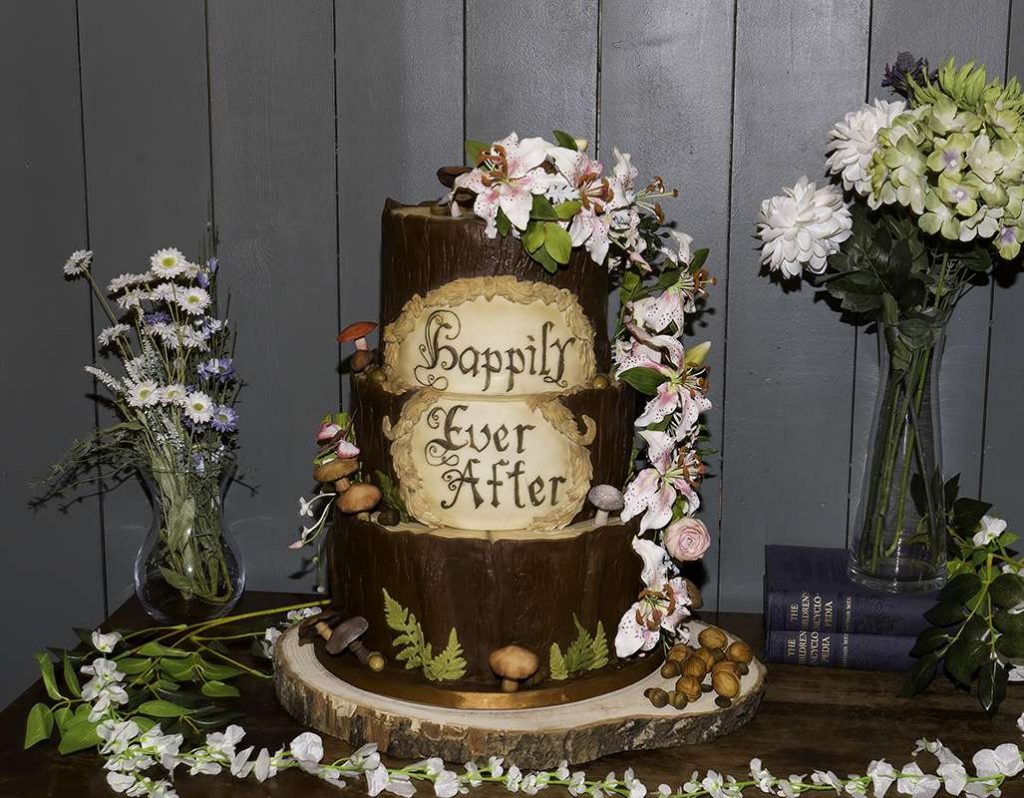 Rustic woodland-themed wedding cake with Happily Ever After topper at Oak Tree Barns Narborough