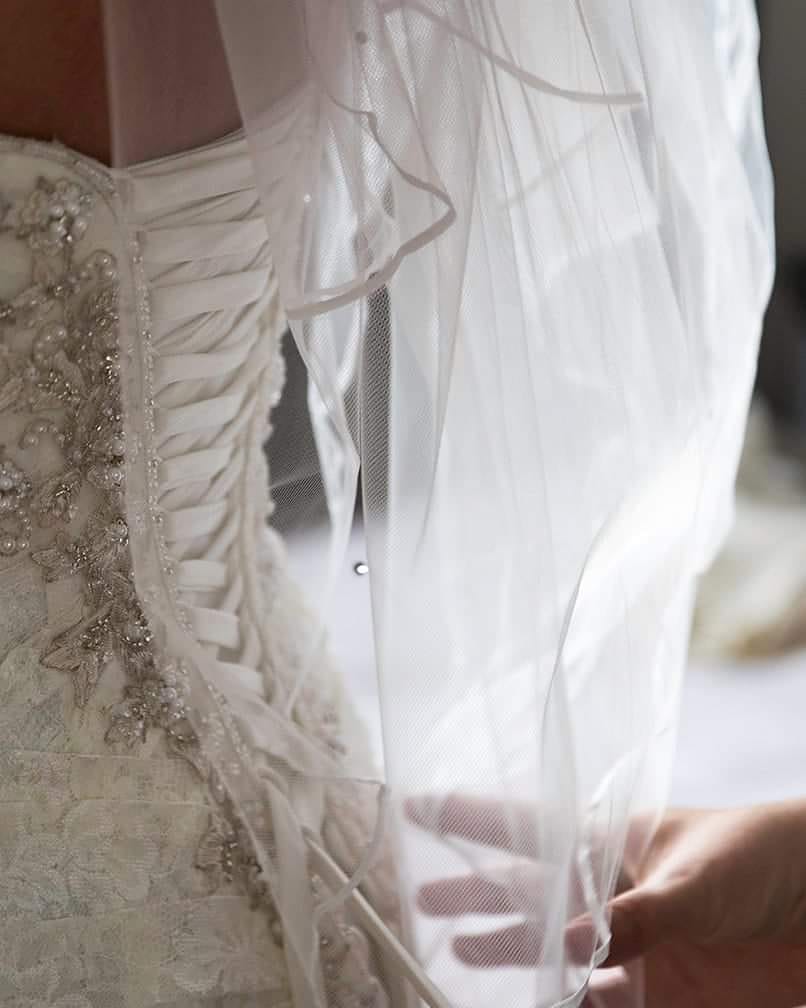 Close-up of intricate wedding dress lace and veil details during a South Wales wedding
